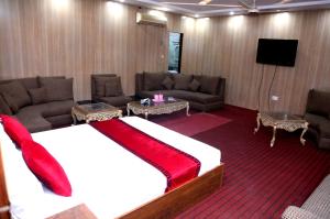 拉合尔Sapphire Inn Motel Lahore的客房设有床、沙发和电视。