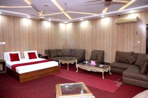 拉合尔Sapphire Inn Motel Lahore的酒店客房,配有床和沙发