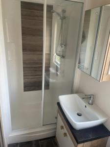 布莱克浦Luxury 6 Berth Caravan, Marton Mere的浴室配有白色水槽和淋浴。
