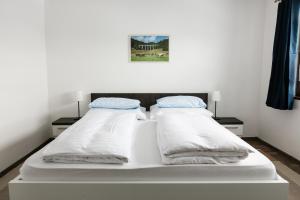 塔加特韩琦旅馆的一张白色的床,上面有两个枕头