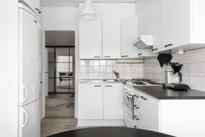波里Fresh 2BR-apartment with FREE parking的厨房配有白色橱柜和黑色台面
