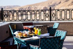 瓦迪穆萨Petra Moon Luxury Hotel的阳台上的桌子上摆放着食物和饮料
