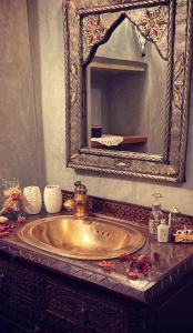 梅克内斯里亚德弗罗斯酒店的浴室设有金色水槽和镜子