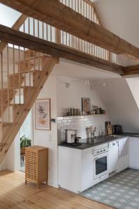 阿沙芬堡Altbau Appartement - klein aber oho的厨房设有白色的柜台和木制楼梯。
