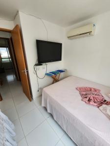 卡博迪圣阿戈斯蒂尼奥Village Mediterrâneo的一间卧室配有一张床和一台平面电视