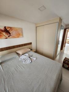 卡博迪圣阿戈斯蒂尼奥Village Mediterrâneo的卧室配有一张白色床,墙上挂有绘画作品
