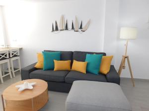 大塔拉哈尔PERLA Penthouse的客厅配有蓝色沙发及色彩缤纷的枕头
