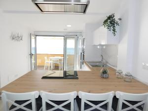 大塔拉哈尔PERLA Penthouse的厨房以及带木桌和椅子的用餐室。