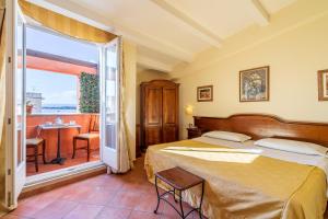 锡拉库扎地中海酒店的一间卧室配有一张床,阳台配有桌子