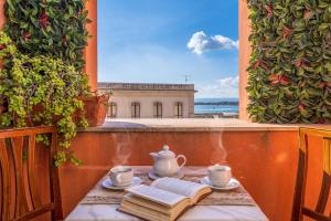 锡拉库扎地中海酒店的阳台上的桌子、茶壶和书籍