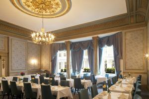 伦敦Gem Strathmore Hotel的一间带桌椅和吊灯的用餐室