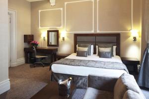 伦敦Gem Strathmore Hotel的酒店客房设有一张大床和一张书桌。