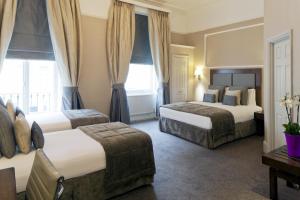 伦敦Gem Strathmore Hotel的酒店客房设有两张床和窗户。