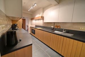 马尔什昂法梅讷Gite Fond des Vaulx的厨房配有黑色台面和木制橱柜