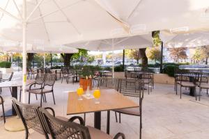 里耶卡欧陆酒店的空荡荡荡的餐厅,配有桌椅和遮阳伞