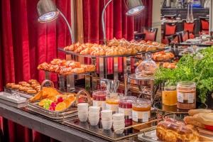 巴黎特里亚农左岸酒店的自助餐,包括不同类型的面包和糕点