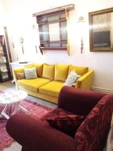 拉马萨The 18, Marsa Guest House的客厅配有黄色的沙发和桌子