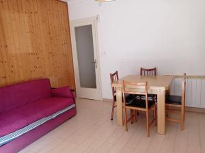 托里代巴拉Apartamento 3 habitaciones centro de Torredembarra的客厅配有桌子和紫色沙发