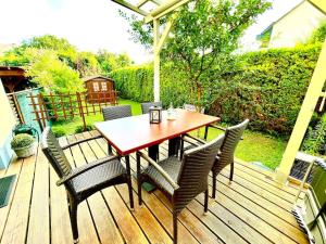 GösselingSchöne Wohnung mit eigenen Eingang und Terrasse的木制甲板配有木桌和椅子