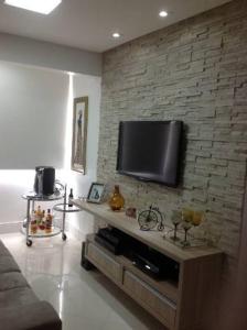 劳鲁-迪弗雷塔斯Apartamento fino e decorado.的一间客厅,在砖墙上配有平面电视