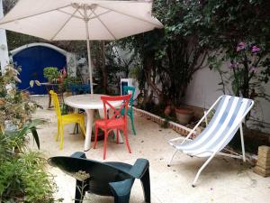 拉马萨The 18, Marsa Guest House的一组椅子和一张桌子及一把伞
