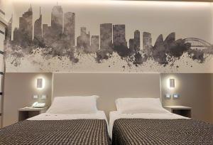 博洛尼亚The Sydney Hotel的一间带两张床的卧室和一幅城市画