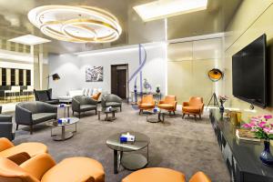利雅德Walaa Homes-Luxury 1Bedroom at DAMAC Esclusiva Tower Riyadh Saudia-708的一间配备有橙色椅子和电视的等候室
