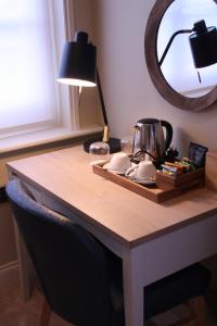 萨克斯曼德姆The Bell Hotel, Saxmundham的一张带镜子的桌子和茶壶