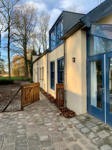 东卡佩勒Koetshuis Buitenplaats Iepenoord的一座带蓝色门和栅栏的房子