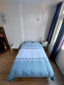 韦尔维耶Studio confort Verviers的一间卧室配有一张带蓝色和白色棉被的床
