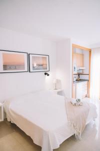 托雷德本纳贾尔邦Apartamento Añoreta Malaga 318的白色卧室设有白色的床和2个窗户
