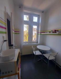 韦尔维耶Studio confort Verviers的客房设有桌椅和窗户。