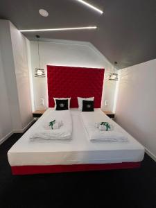 莱扎伊斯克Centrum Bankietowo - Hotelowe "Perła"的一间卧室配有一张大床和红色床头板