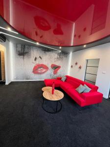 莱扎伊斯克Centrum Bankietowo - Hotelowe "Perła"的客厅配有红色的沙发和桌子