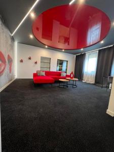 莱扎伊斯克Centrum Bankietowo - Hotelowe "Perła"的客厅配有红色的沙发和桌子
