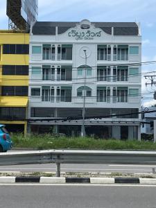 清迈Wiang Ville Boutique Hotel的白色的建筑,在建筑的侧面写字