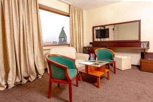 Vratsa赫姆斯酒店 - 瓦拉特萨的一间设有两把椅子、一张桌子和一台电视的房间