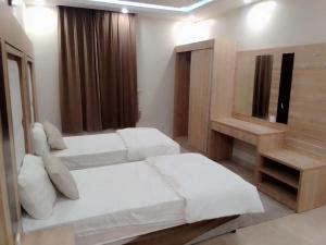 Aḩad al MasāriḩahAdmire Apart Hotel - 2的一间卧室配有两张床、一张桌子和一面镜子