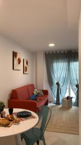 福恩吉罗拉Bnbook Medea Apartments 2的客厅配有红色的沙发和桌子