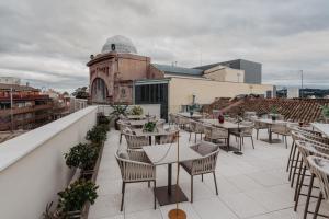 特拉萨Hotel Petit Luxe的屋顶餐厅设有桌椅