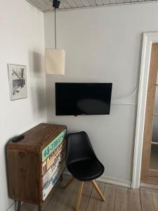 欧登塞City House的一间房间,墙上有椅子和电视