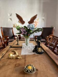 MompósHotel Archangelus的鸟儿桌子上的花瓶