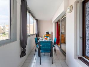 阿格德角Apartment Amourêva-1 by Interhome的一间带桌子和蓝色椅子的用餐室