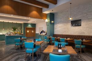 多哈ibis Doha的餐厅设有木桌和蓝色椅子
