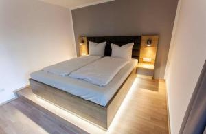 雷根斯堡The Room的一间卧室配有带白色床单和枕头的床。