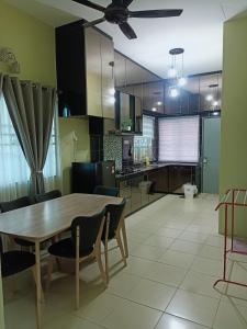 TeronohFidaiy Homestay的厨房以及带木桌和椅子的用餐室。