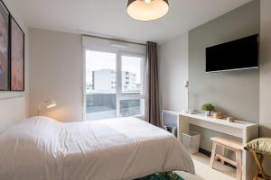 勒阿弗尔Student Factory Le Havre Les Docks的一间卧室配有一张床、一张书桌和一个窗户。