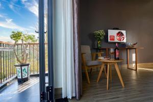 会安An Bang MQ Villa的客房设有带桌子和电视的阳台。
