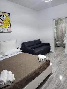 马泰拉Dimore Pietrapenta Apartments, Suites & Rooms - Via Lucana 223, Via Piave 23, Via Chiancalata 16的一间卧室配有一张床和一张黑色沙发