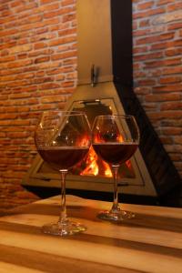 沃斯科波亚Vila Strugu的壁炉前的桌子上放着两杯葡萄酒